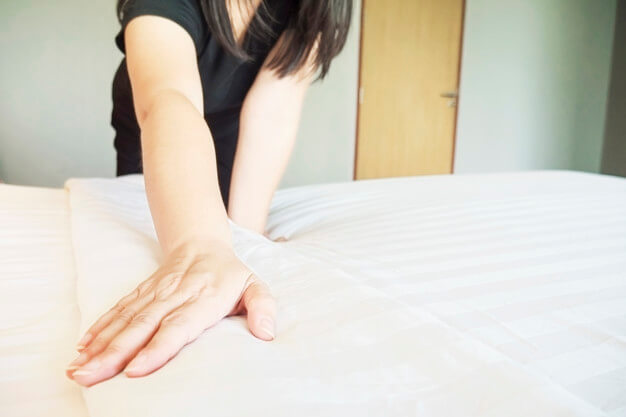 ladyhandssetupwhitebedsheethotelroom11506436 1 6172 1