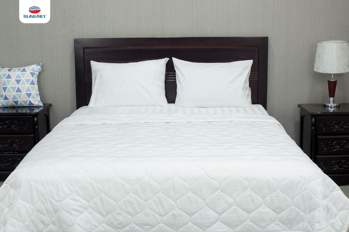 Bộ chăn ga gối màu trắng tinh khôi, cho thấy sự sang trọng